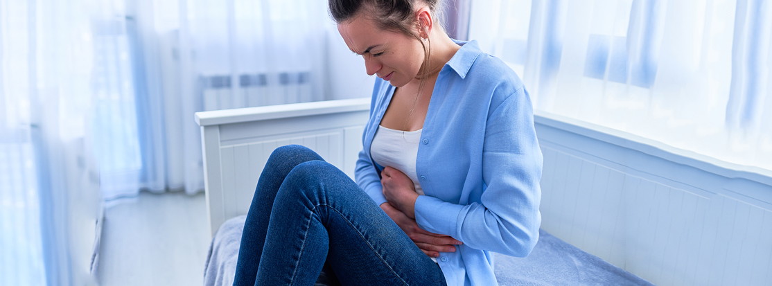 Mujer que sufre de un fuerte espasmo dolor de estómago durante la úlcera gástrica 