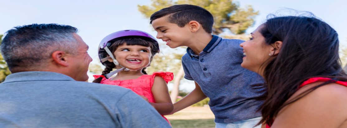 papá, niña con casco sonriendo, niño y mama