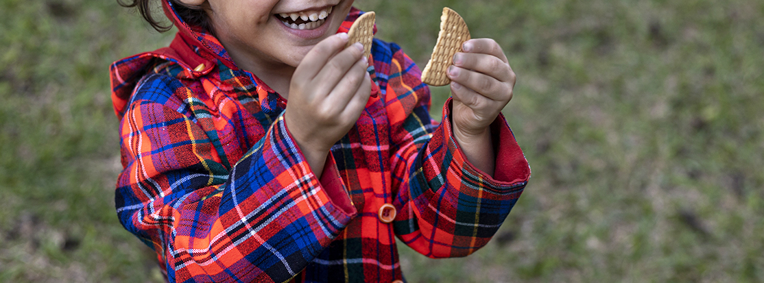 niño con manos sucias sostiene galletas